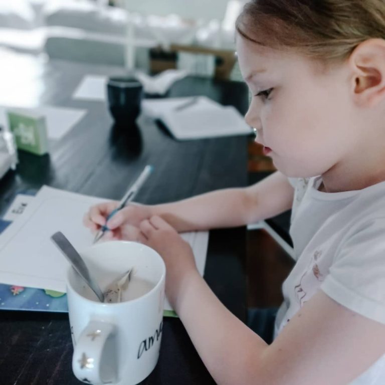 girl journaling with a cup of tea